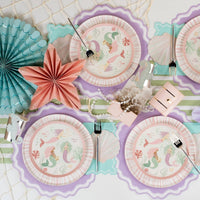mermaid party table with lavender placemats, shells, and paper fans