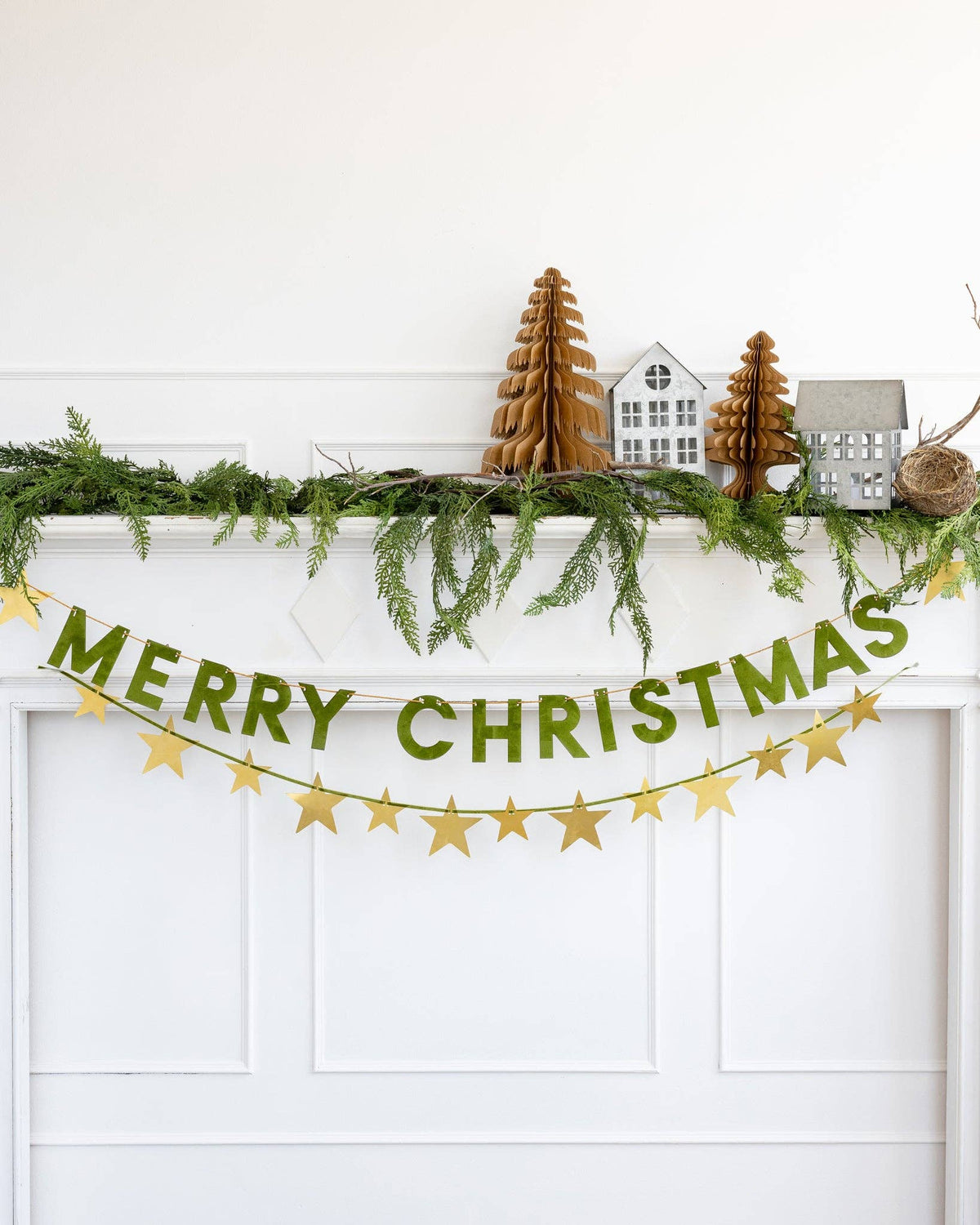 Merry Christmas flocked banner styled across a doorway with greenery