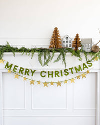 Merry Christmas flocked banner styled across a doorway with greenery