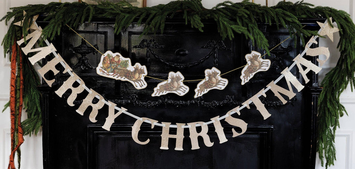Merry Christmas glitter banner styled on a mantel with greenery