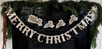 Merry Christmas glitter banner styled on a mantel with greenery