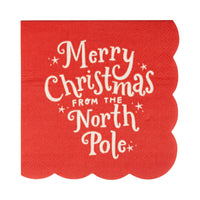 Red cocktail napkin with “Merry Christmas from the North Pole” text and scalloped edges