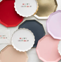 Birthday plates spread: Display of colorful birthday and solid plates including navy blue octagon plate with gold edges.