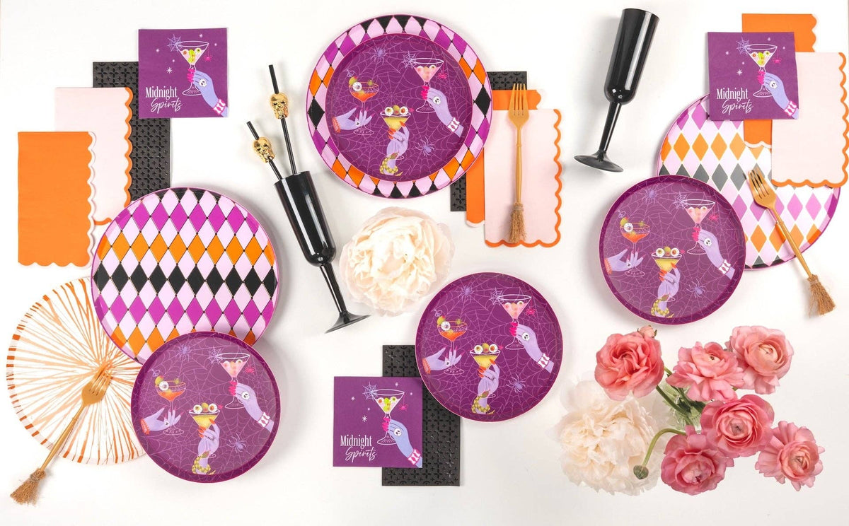 Flat lay of the complete Midnight Spirits Halloween collection, including purple plates, napkins, orange decor, and black drinkware.