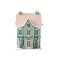 Front view of a mint Christmas paper house with a pink roof on a white background