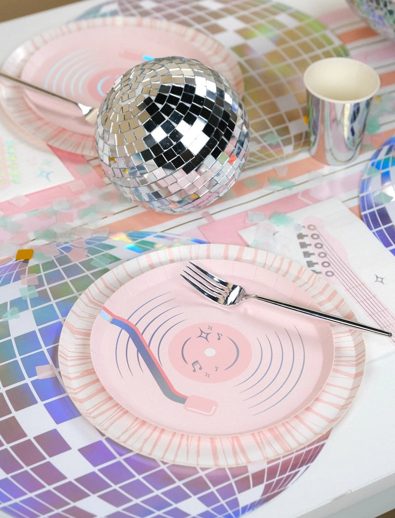 14 inch iridescent disco ball placemat layered under a pink vinyl record plate next to a silver mirror ball.