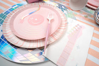 Side angle of a stage-worthy table setting showing the holographic shine of the disco ball placemat and pink cutlery.