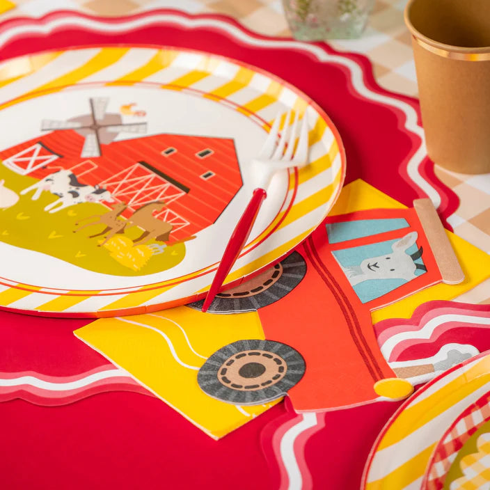 Plate with red barn design and a tractor napkin tucked under the fork.