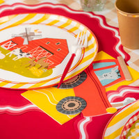 Plate with red barn design and a tractor napkin tucked under the fork.