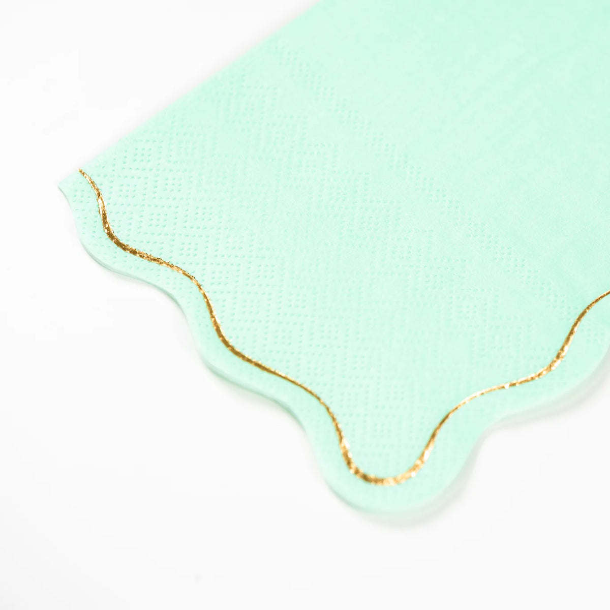 Closeup of icy blue guest towel with scalloped gold foil edge.