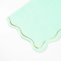 Closeup of icy blue guest towel with scalloped gold foil edge.