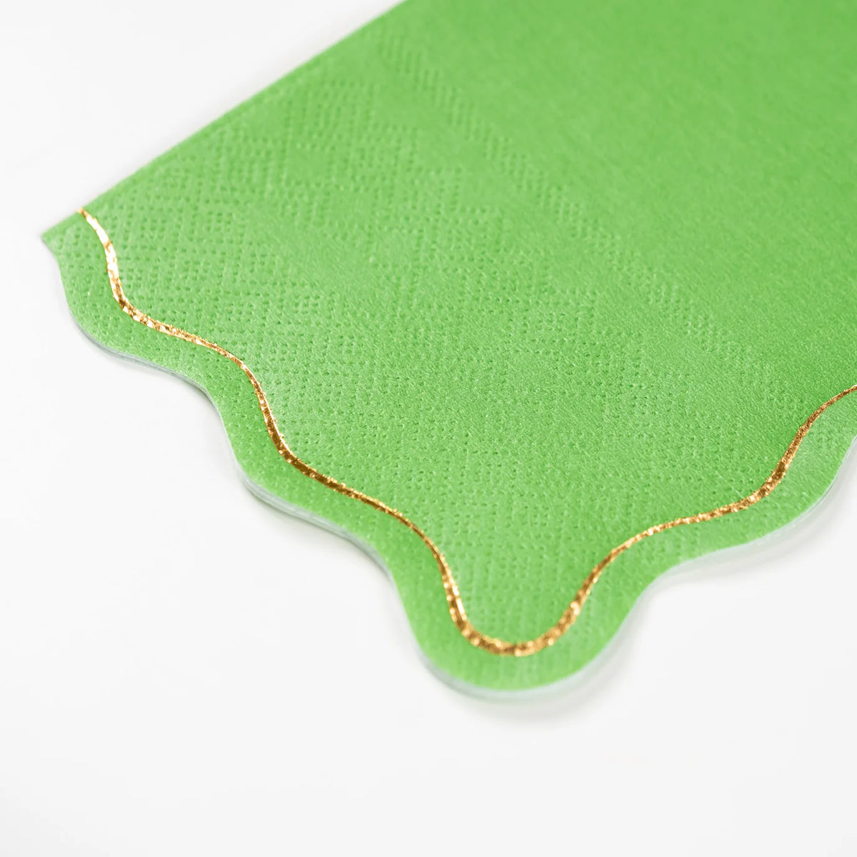 Closeup of evergreen guest towel with scalloped gold foil edge.