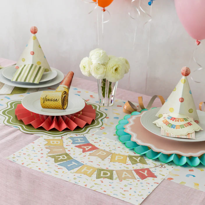 Birthday table with balloons and flowers using a confetti runner beneath a happy birthday banner placemat.