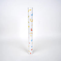 Upright roll of paper table runner printed with watercolor confetti on white.