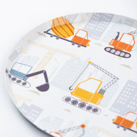 Closeup of paper dessert plate with cranes, digger, mixer, and trucks.
