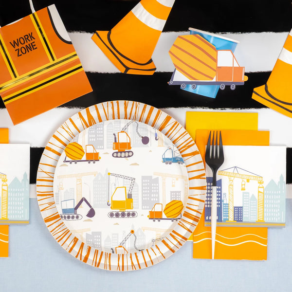 Overhead table set with construction plates, cones, napkins, and party props.