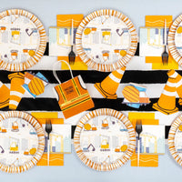 Overhead construction party table with cones, plates, and truck stickers used as accents.