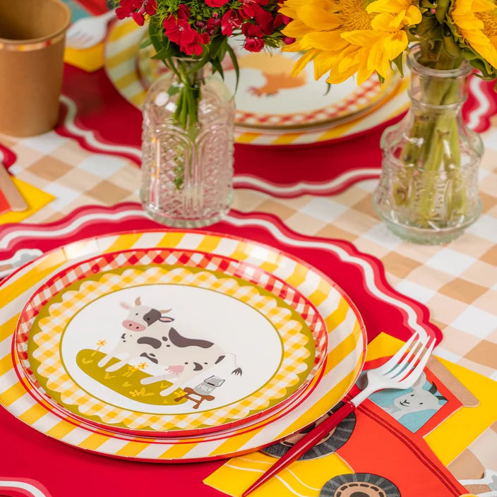 Cow plate place setting styled with a tractor napkin and gingham details.