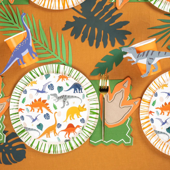Overhead table spread with dino plates and leaf decor plus accent stickers.