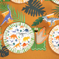 Overhead table spread with dino plates and leaf decor plus accent stickers.