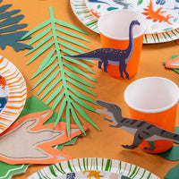 Dino party table with cups and plates styled with blue long neck and gray T-Rex stickers.