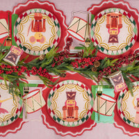 Overhead tablescape with multiple character plates and drum napkins layered on red placemats.