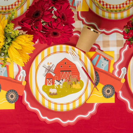Farm party table with barn plates, flowers, and tractor napkins at each place.