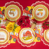 Overhead farm tablescape with multiple tractor napkins and bright flowers.