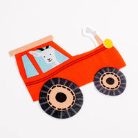 Shaped red tractor napkin with goat driver on white background.