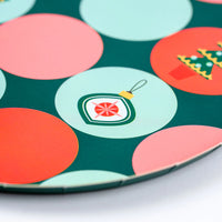 Closeup of dot pattern with small ornament and tree icons on a dark green plate.