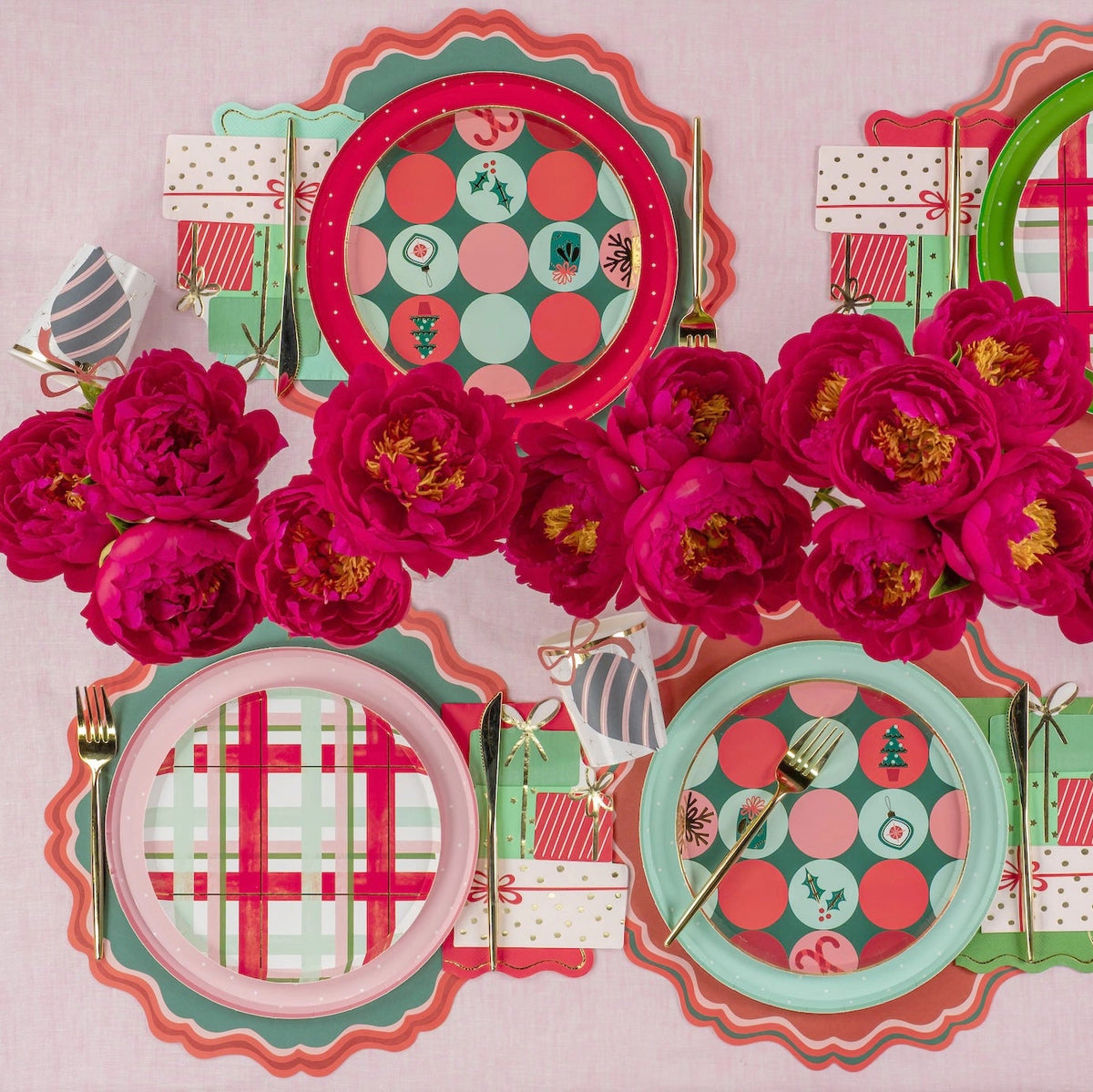 Mixed holiday place settings with dot and plaid plates around bright pink peonies.