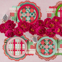 Mixed holiday place settings with dot and plaid plates around bright pink peonies.