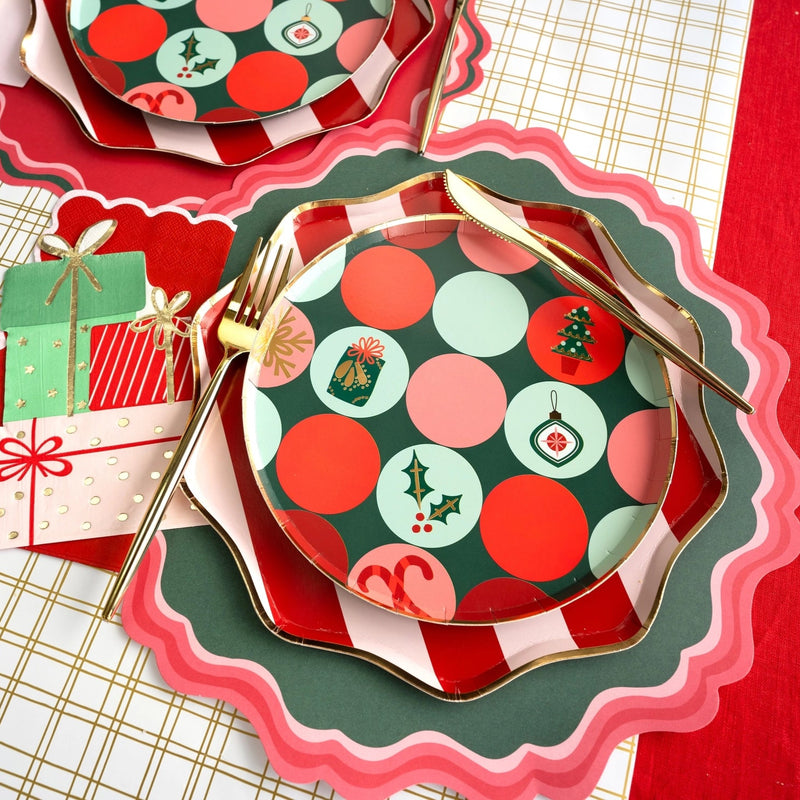 Stacked plates with striped charger and dot dessert plate on a gold grid table runner.