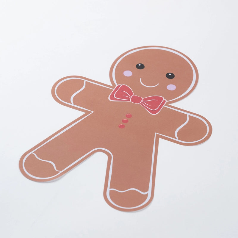Full gingerbread man paper placemat angled on white with red buttons visible.