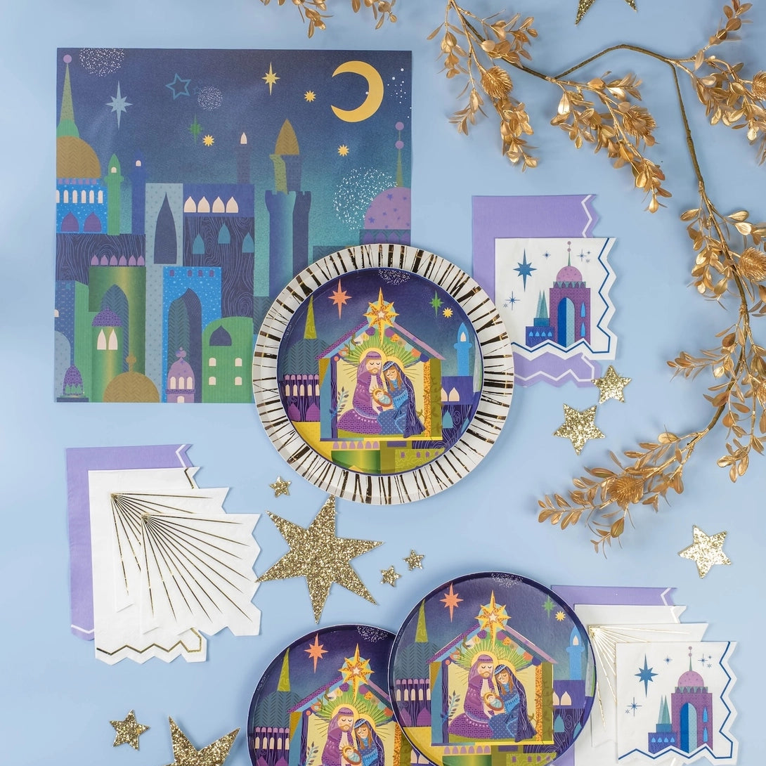 Flat lay of starry plates and white napkins with gold rays on a blue backdrop.