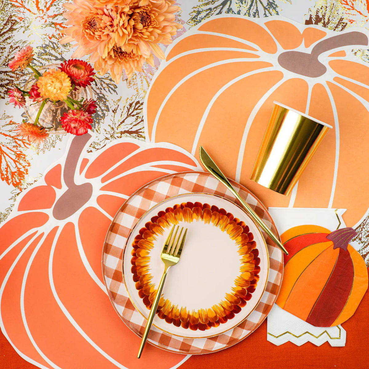 Overhead pumpkin tablescape with a white guest towel trimmed in gold at the place setting.