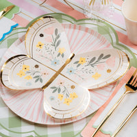 Close view of butterfly plate layered on green gingham placemat with gold flatware.