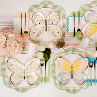 Overhead table with multiple green gingham scalloped placemats and pastel runner.