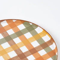 Angled close view of the gingham plaid pattern on the dinner plate rim.