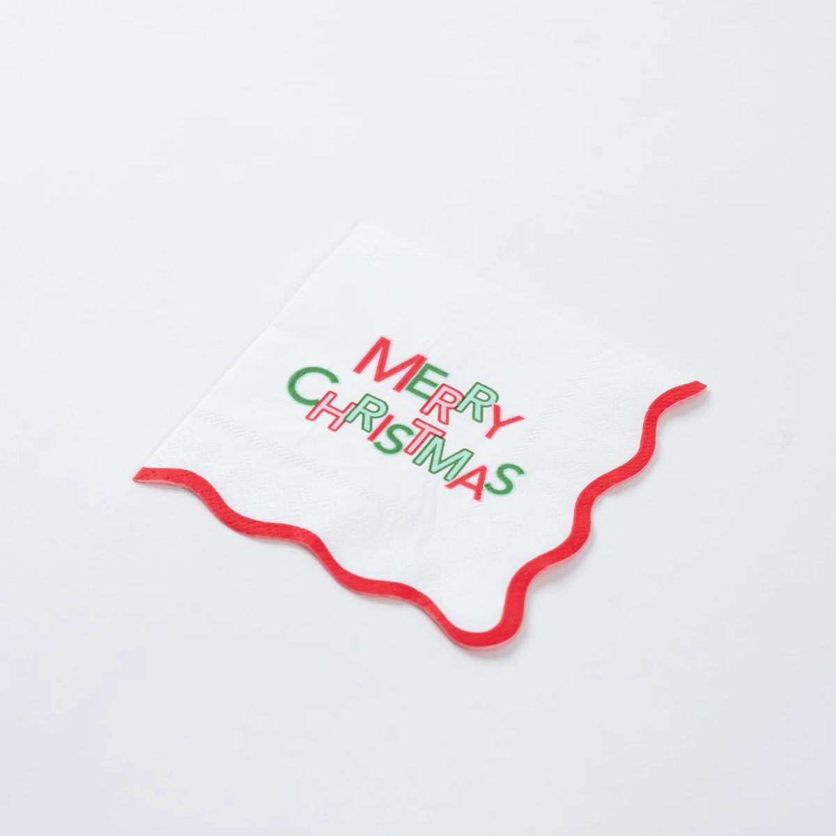 Single Merry Christmas cocktail napkin with wavy red border on white background.