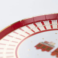 Closeup of red rim with thin gold foil edge on North Pole Express dessert plate.
