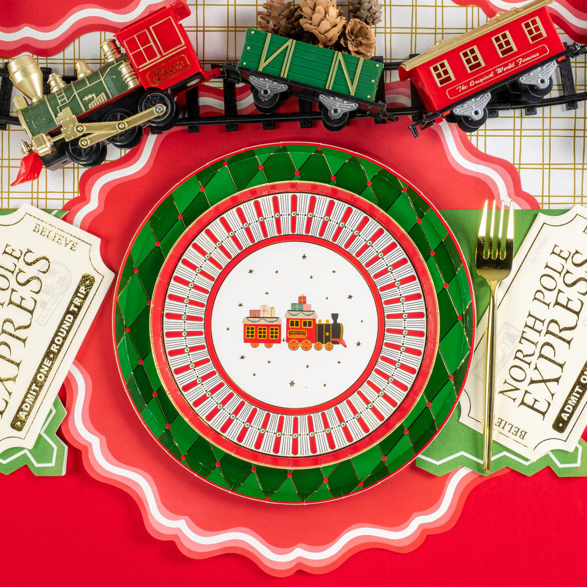 Single place setting with train dessert plate centered under a toy train garland.