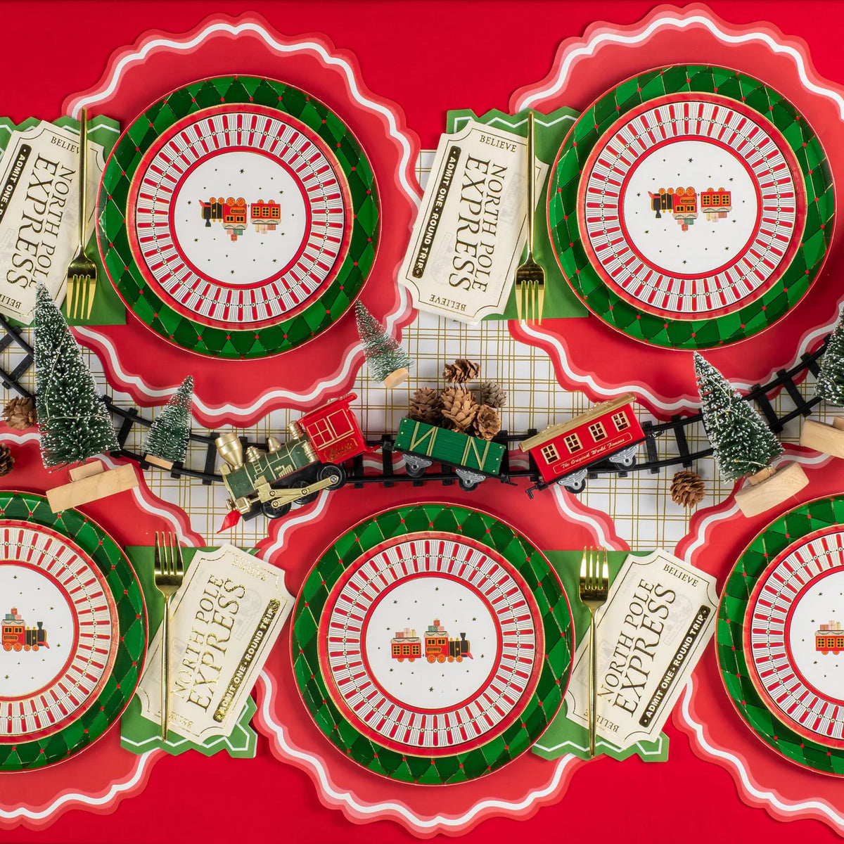 Overhead table with multiple train dessert plates and a mini holiday train centerpiece.