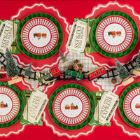Overhead table with multiple train dessert plates and a mini holiday train centerpiece.