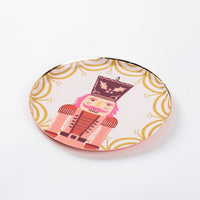 Single Nutcracker dessert plate on blush pink with gold accents.
