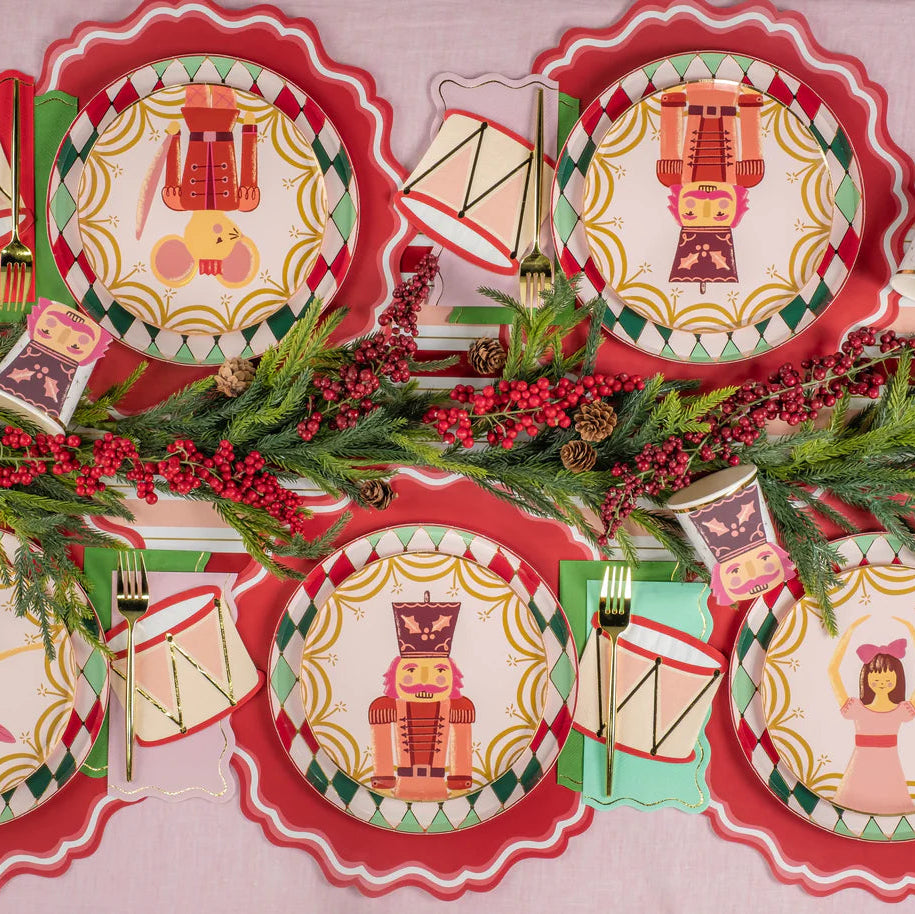 Overhead tablescape with all four Nutcracker Ballet dessert plates and evergreen garland.