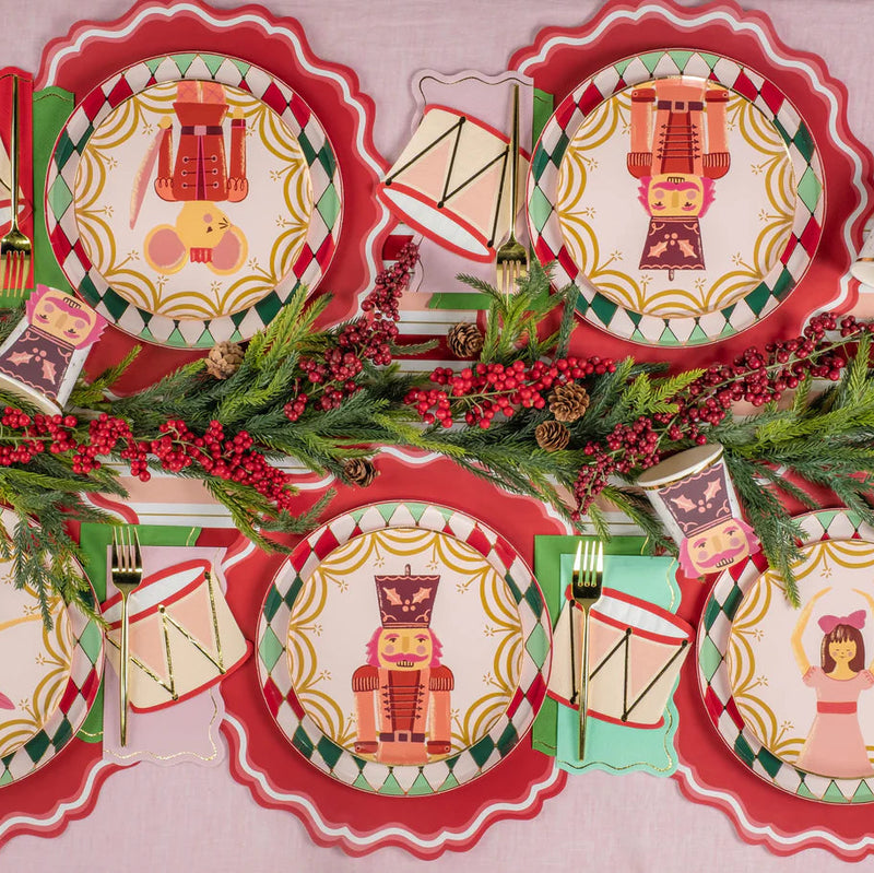 Overhead tablescape with all four Nutcracker Ballet dessert plates and evergreen garland.