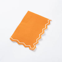 Folded orange guest towel showing zigzag border.