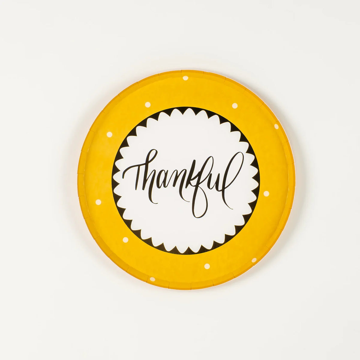 Mustard yellow dessert plate with “thankful” in script and white dots on the rim.