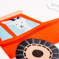 Closeup of tractor napkin window showing smiling goat illustration.